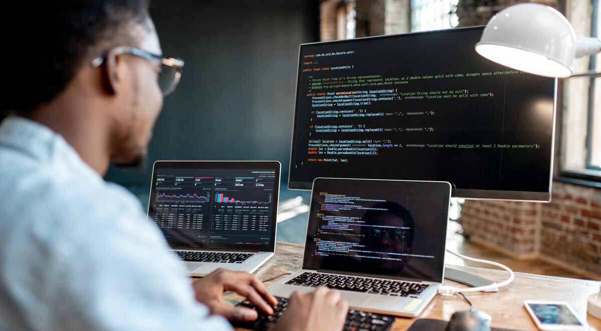 man looking through code on computer screen